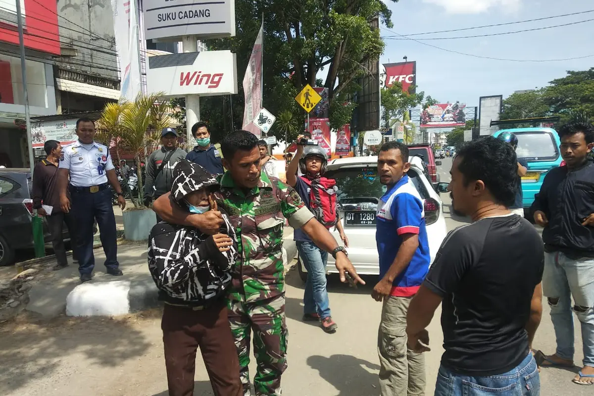 Seorang pria berseragam anggota TNI, membubarkan kelompok tawuran pelajar di Kendari, Jumat (6/12/2019).(Liputan6.com/Ahmad Akbar Fua)