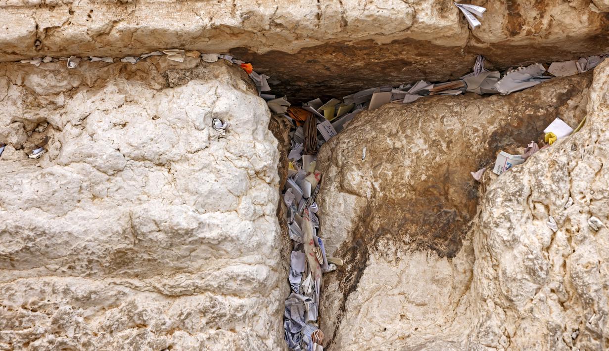 Catatan doa ditinggalkan oleh umat Yahudi di celah-celah Tembok Barat - situs paling suci di mana orang Yahudi diizinkan untuk berdoa - di kota tua Yerusalem pada 20 September 2022. Pembersihan ini untuk memberi ruang bagi catatan baru menjelang Tahun Baru Yahudi. (AFP/Ahmad Gharabli)