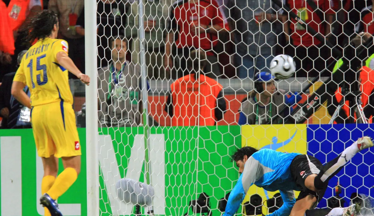 Artem Milevskiy. Eks striker Ukraina yang belum lama pensiun pada September 2021 ini menjadi pemain kedua yang melakukan eksekusi penalti dengan gaya Panenka di Piala Dunia. Momen itu terjadi saat Ukraina menang melalui adu penalti 3-0 (0-0) atas Swiss pada babak 16 besar Piala Dunia 2006 (26/6/2006) di Jerman. Sebagai penendang kedua, eksekusi penalti Panenka-nya mampu memperdaya kiper Swiss, Pascal Zuberbuhler. (AFP/Odd Andersen)