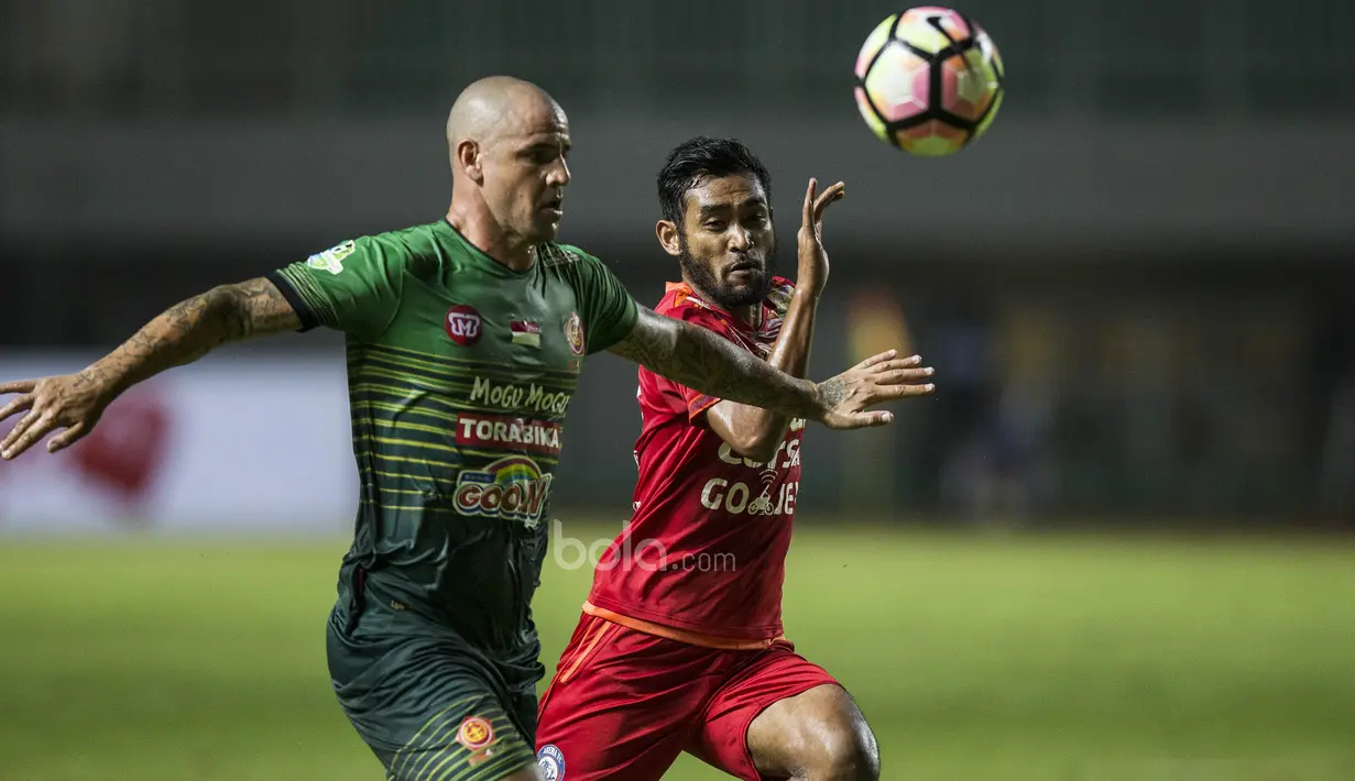Bek PS TNI, Facundo Talin, mengamankan bola dari kejarang gelandang Arema FC, Ferry Saragih, pada laga Liga 1 di Stadion Pakansari, Bogor, Senin (3/7/2017). Kedua klub bermain imbang 0-0. (Bola.com/Vitalis Yogi Trisna)