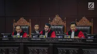 Ketua Majelis Hakim Konstitusi Anwar Usman (tengah) saat membacakan putusan MK di Gedung MK, Jakarta, Kamis (27/6/2019). MK menolak seluruh gugatan hasil Pilpres 2019 yang diajukan Prabowo Subianto-Sandiaga Uno yang disepakati sembilan hakim konstitusi. (Liputan6.com/Faizal Fanani)