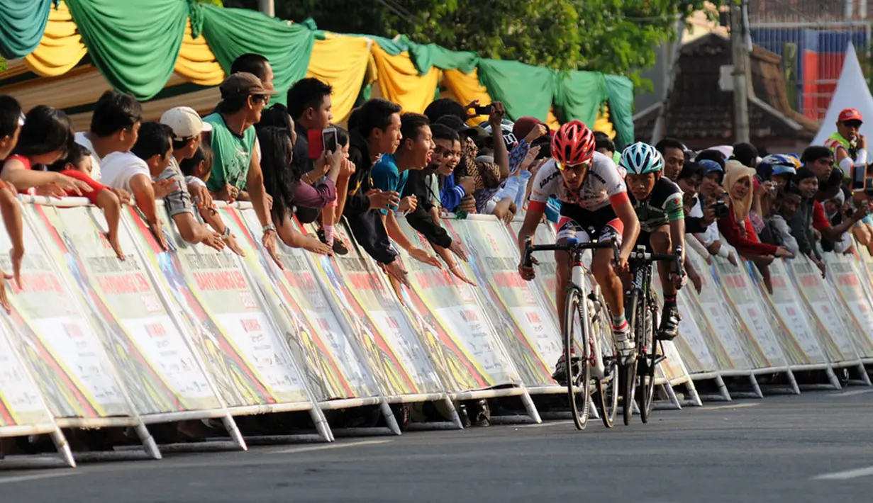 Sejumlah penonton memberikan semangat pada dua pebalap terdepan yang bertarung di etape keempat Internasional Tour De Banyuwangi Ijen,  (19/10/2014).  (Liputan6.com/Helmi Fithriansyah) 