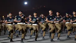 Angkatan bersenjata Saudi berbaris dalam sebuah parade di kota suci Arab Saudi di Mekkah (23/8). Bagi umat Islam yang mampu ibadah haji merupakan kewajiban yang harus dilakukan setidaknya sekali seumur hidup. (AFP Photo/Bandar Aldandani)