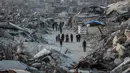 Akses bantuan, terutama ke wilayah utara Gaza, masih sangat terbatas, dan banyak permintaan bantuan ditolak oleh pihak berwenang Israel. Tampak dalam foto, warga Palestina berjalan di antara puing-puing bangunan yang hancur di Jabalia, di bagian utara Jalur Gaza, pada Jumat 7 November 2025. (Omar AL-QATTAA/AFP)