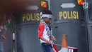 Seorang anak melintas di depan tameng polisi saat aksi dukungan bagi negara Palestina di depan Kedubes AS, Jakarta, Minggu (10/12). Mereka memprotes keputusan Presiden Trump yang mengakui Yerusalem jadi Ibu Kota Israel. (Liputan6.com/Helmi Fithriansyah)