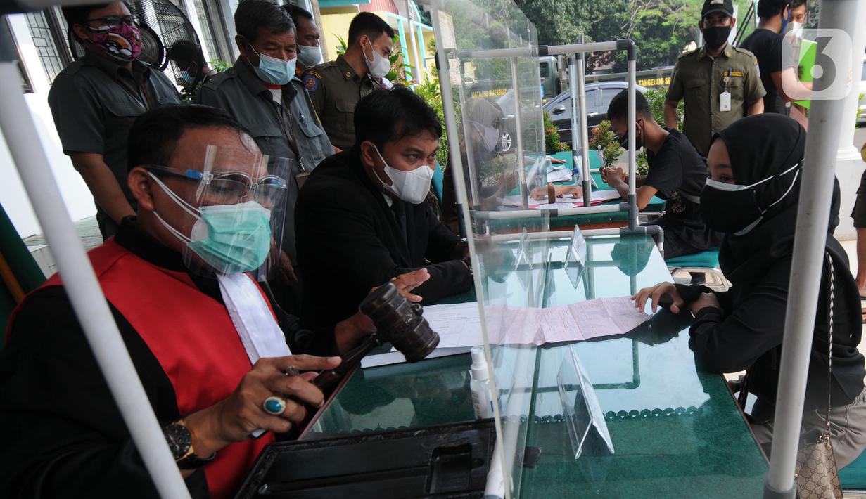 Hakim mengetuk palu saat Sidang Tipiring pelanggaran PPKM Darurat di kantor Kecamatan Pamulang, Tangerang Selatan, Banten, Senin (19/7/2021). Dua puluh empat pelanggar diantaranya tidak bermasker dan jam operasional tempat usaha didenda Rp 100 ribu hingga Rp 500 ribu. (merdeka.com/Arie Basuki)