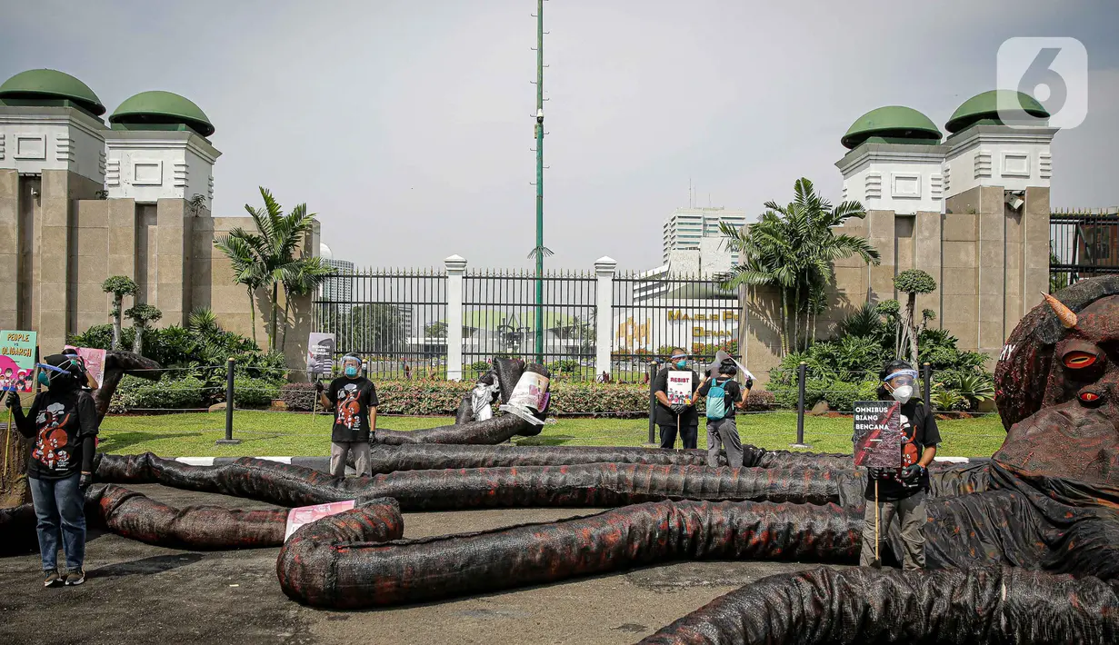 Aktivis Greenpeace menggelar aksi di depan Gedung DPR RI, Jakarta, Selasa (5/10/2021). Dalam aksinya, mereka membawa gurita raksasa sebagai simbol oligarki serta menyerukan kepada pemerintah agar serius mengatasi pandemi dan memberantas korupsi energi. (Liputan6.com/Faizal Fanani)
