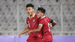 Pemain Timnas Indonesia, Arkhan Fikri (kanan) merayakan gol pertama timnya ke gawang Timnas Fiji bersama rekannya, Ginanjar Wahyu Ramadhani pada laga International Friendly Match U-20 di Stadion Utama Gelora Bung Karno (SUGBK), Jakarta, Jumat (17/02/2023). (Bola.com/Bagaskara Lazuardi)