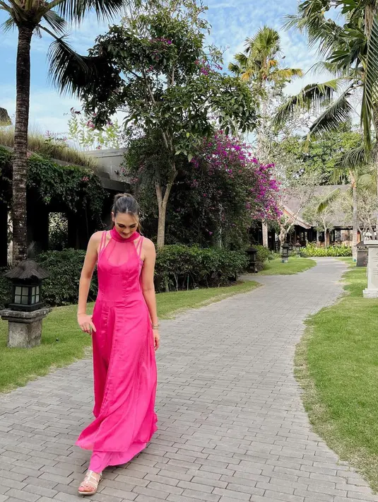 Gaun berpotongan kerah halter lainnya juga terlihat dalam foto lain yang dibagikan Luna Maya. Kali ini berwarna pink bold dengan atasan halter menerawang dan strap yang cantik. (Foto: Instagram @lunamaya)