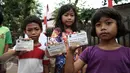 Tiga orang anak menunjukkan Kartu Jakarta Pintar (KJP) saat operasi daging murah di Kantor Kecamatan Matraman, Jakarta, Senin (27/6). Operasi pasar ini menjual daging sapi dan ayam murah untuk pemegang KJP Sekolah Dasar (SD). (Liputan6.com/Faizal Fanani)