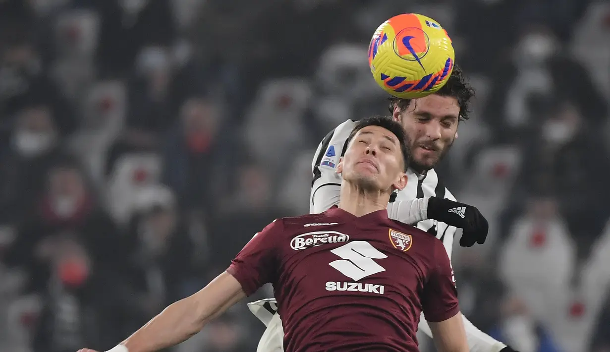 Gelandang Torino Sasa Lukic (depan) berebut bola dengan gelandang Juventus Manuel Locatelli dalam pekan 26 Serie A Liga Italia di Allianz Stadium, Sabtu (19/2/2022) dinihari WIB. Juventus ditahan imbang Torino 1-1. (Filippo MONTEFORTE / AFP)