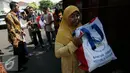 Warga membawa semboko dari Presiden Jokowi saat open house di Istana Kepresidenan Gedung Agung, Yogyakarta, Sabtu (9/7). Open House ini diikuti oleh ribuan masyarakat yang berada di Yogyakarta. (Liputan6.com/Boy Harjanto)