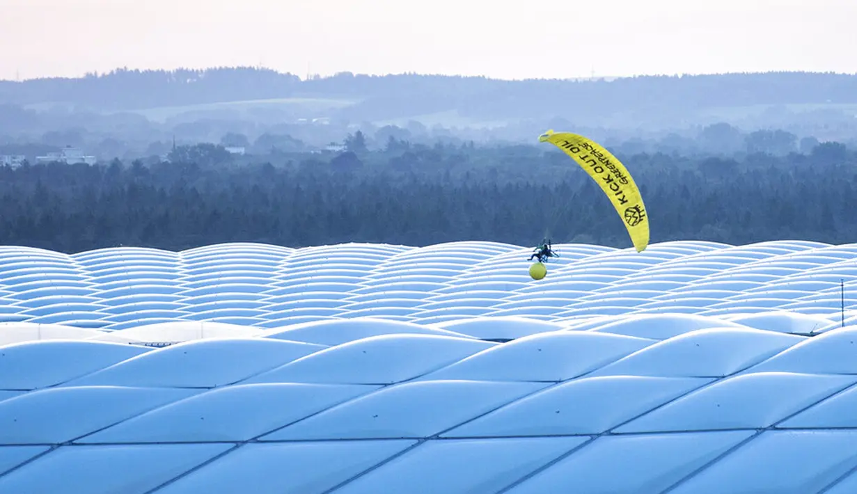 Paraglider Greenpeace terbang ke stadion sebelum pertandingan Grup F Euro 2020 antara Prancis dan Jerman di Allianz Arena, Munich, Jerman, Selasa (15/6/2021). Sang aktivis sempat mengenai peralatan spidercam. (Matthias Balk/DPA via AP)