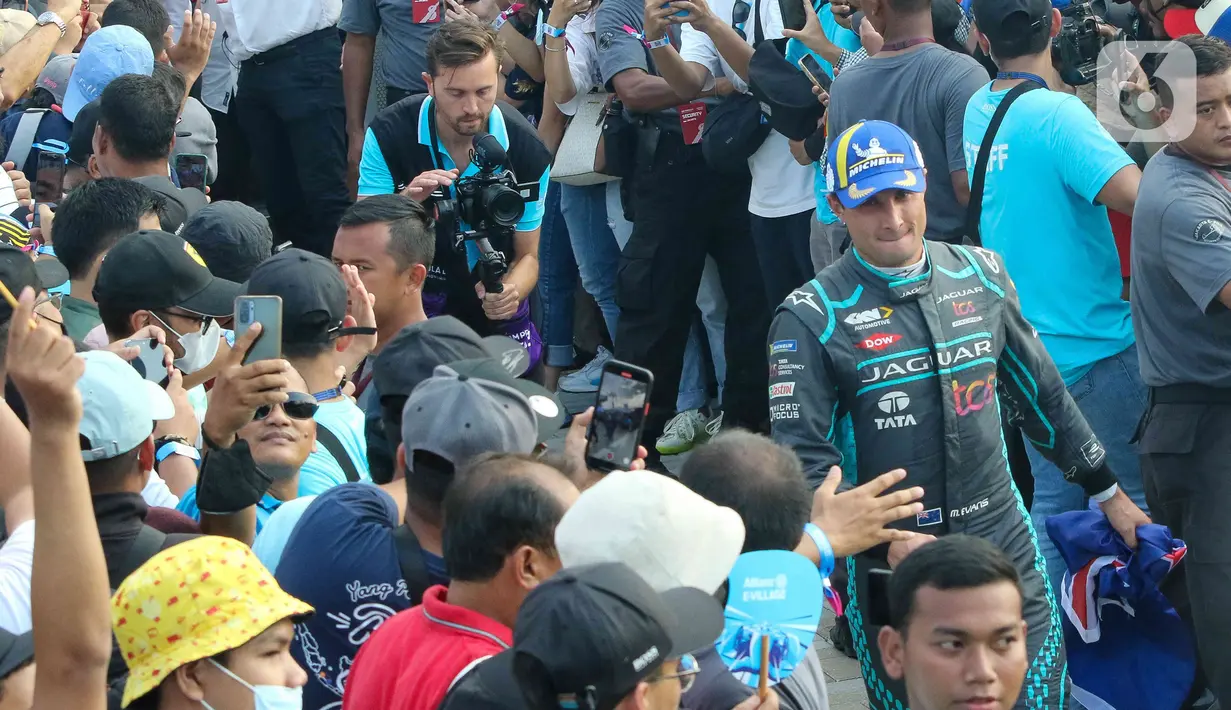 Penonton bersalaman dengan pembalap Jaguar TCS Racing Mitch Evans saat ajang Formula E di Jakarta International E-Prix Circuit (JIEC), Jakarta, Sabtu (4/6/2022). Andalan Jaguar TCS Racing Mitch Evans memenangkan ajang balap Formula E Jakarta e-Prix 2022. (Liputan6.com/Herman Zakharia)