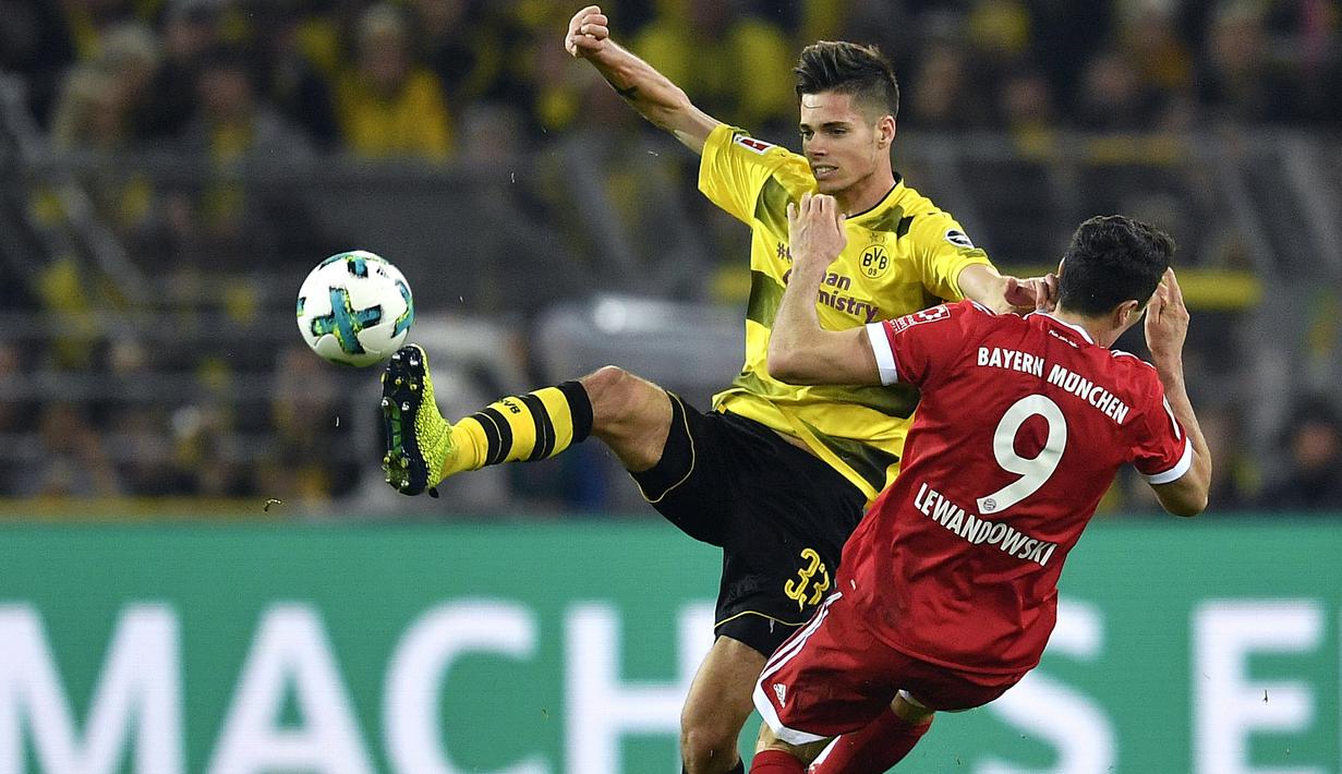 Pemain Dortmund, Julian Weigl (kiri) menghalau bola dari kejaran pemain Bayern, Robert Lewandowski pada lanjutan Bundesliga di Signal Iduna Park, Dortmund, (4/11/2017). Bayern menang 3-1. (AP/Martin Meissner)