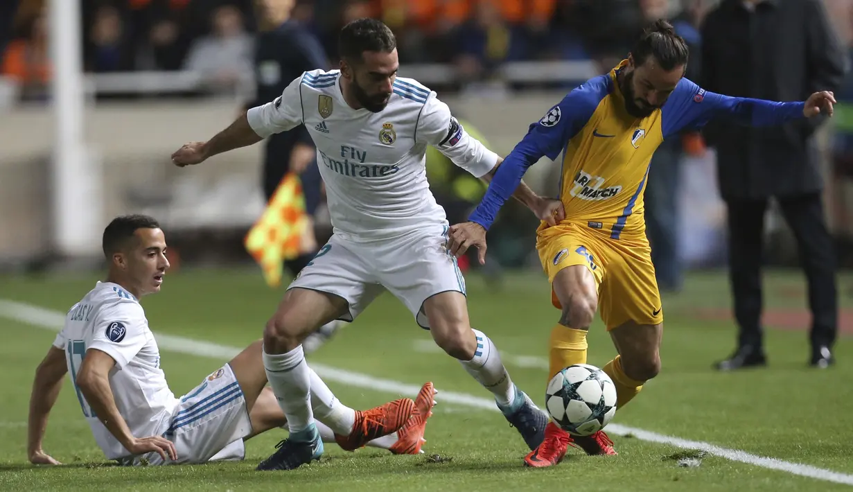 Pemain Real Madrid, Daniel Carvajal (tengah) beebut bola dengan pemain APOEL, Efstathios Aloneftis (kanan)  pada laga Liga Champions grup H di GSP stadium, Nicosia, (21/11/2017). Madrid menang 6-0. (AP/Petros Karadjias)