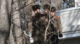Tiga tentara Korea Utara mengawasi kunjungan Menhan Korsel, Song Young-moo di zona Demiliterisasi Panmunjom, (27/11). Tentara Korut terus mengawasi kunjungan Song Young-moo dan mendengarkan pembicaraan dengan jarak hanya 10 meter. (AP Photo/Lee Jin-man)