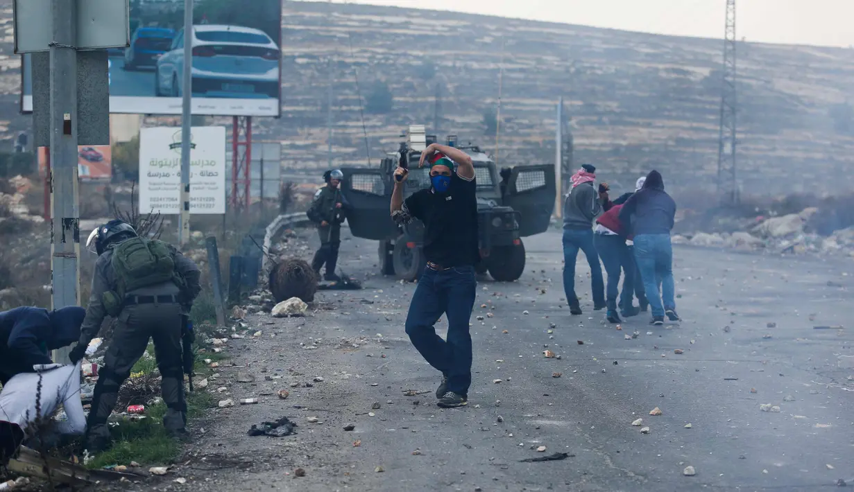 Suasana saat penangkapan demonstran Palestina di kota Ramallah, Tepi Barat, (13/12). Para demonstran menentang keputusan Presiden AS, Donald Trump terkait Yerusalem sebagai ibu kota Israel. (AP Photo / Nasser Shiyoukhi)