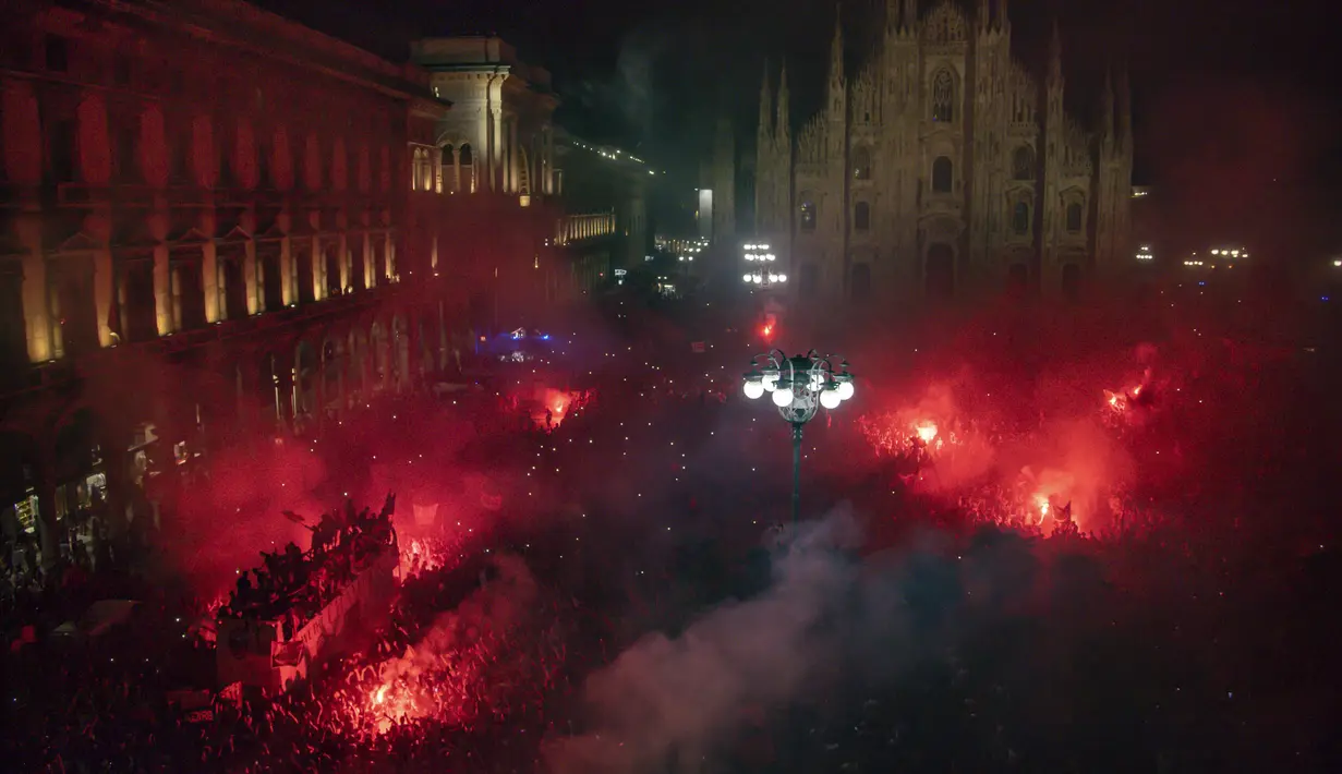 Ribuan penggemar bersorak saat bus yang membawa para pemain tim sepak bola AC Milan melakukan parade kemenangan Liga Italia di depan Katedral Gotik Milan, Milan, Italia, 23 Mei 2022. (LaPresse via AP)