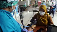 Dokter memeriksa kondisi seorang wanita sebelum melakukan vaksinasi virus corona COVID-19 produksi Sinovac di Puskemas Jagakarsa, Jakarta Selatan, Kamis (14/1/2020). Sejumlah Puskesmas di Jabodetabek mulai melakukan vaksinasi COVID-19 pada hari ini. (merdeka.com/Arie Basuki)
