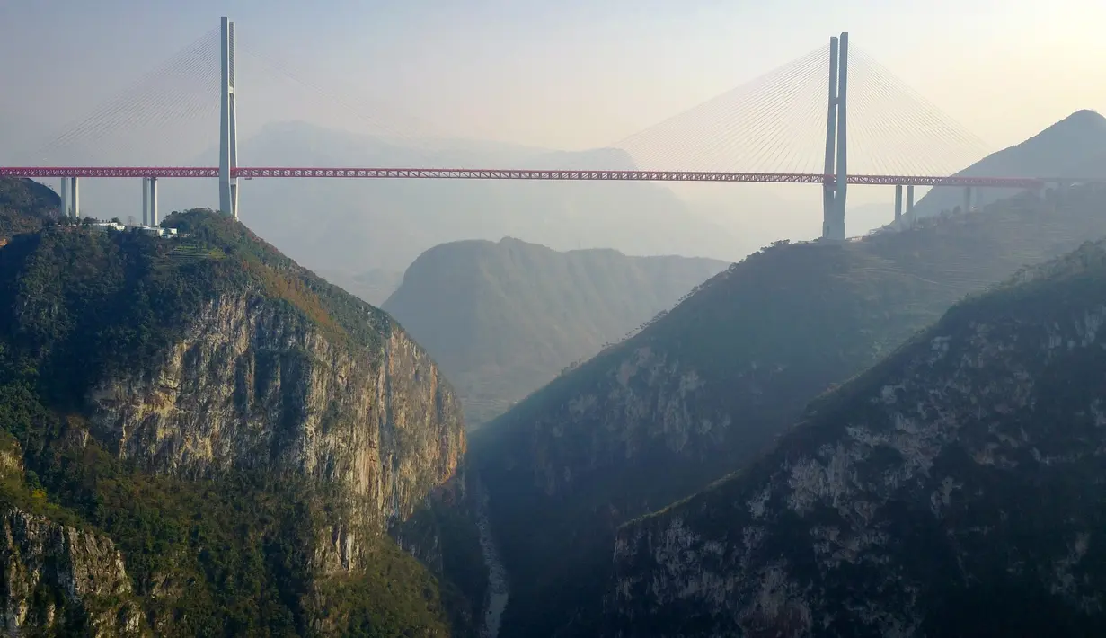 Gambar yang diambil pada 28 Desember 2016 menunjukkan jembatan Beipanjiang di dekat Bijie, Provinsi Guizhou, China. Jembatan baru yang berada di wilayah barat daya China itu diklaim sebagai jembatan tertinggi di dunia. (STR / AFP)