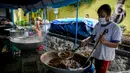 Petugas Taruna Siaga Bencana (Tagana) menggoreng daging ayam di Dapur Umum Kementerian Sosial di GOR Otista, Jakarta, Minggu (21/2/2021). Dalam sehari, petugas menyiapkan hingga 6.000 paket nasi kotak yang didistribusikan ke 11 kelurahan terdampak banjir. (Liputan6.com/Faizal Fanani)