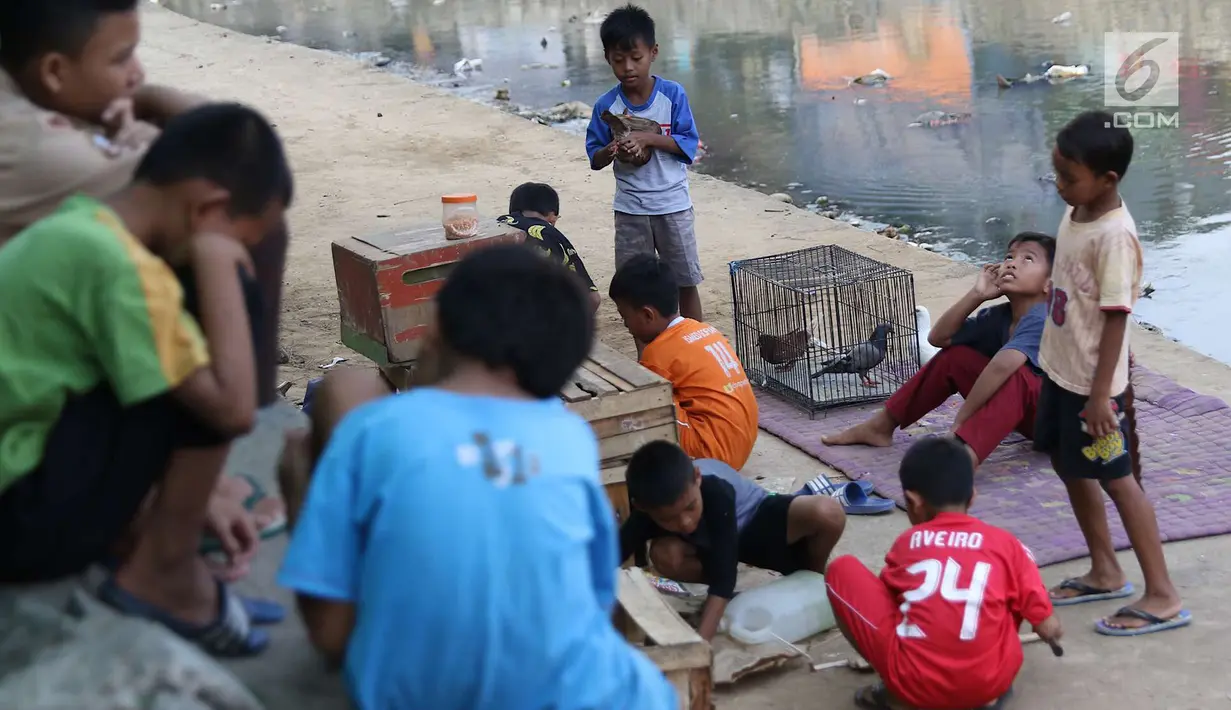 Anak-anak bermain di bantaran anak Sungai Ciliwung, Jakarta, Rabu (6/6). Meskipun tidak layak sebagai tempat bermain, namun lokasi itu menjadi tempat bagi anak-anak di kawasan tersebut untuk menunggu waktu berbuka. (Liputan6.com/Immanuel Antonius)