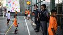 Polisi ikut bermain bola voli saat menjaga Anak-anak pada program Volleyball Development Training yang digagas oleh Federasi Bola Voli Internasional di Formiga favela, Rio de Janeiro, (2/8/2016). (AFP/Leon Neal)