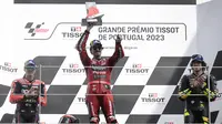 Selebrasi Pebalap Ducati Lenovo, Francesco Bagnaia di atas podium setelah menjuarai balapan MotoGP Portugal 2023 di Sirkuit Internasional Algarve, Portimao, Portugal, Minggu (26/3/2023). Posisi kedua ditempati pebalap Aprilia Racing, Maverick Vinales (kiri) dan posisi ketiga menjadi milik pebalap Mooney VR46 Ducati, Marco Bezzecchi (kanan). (AFP/Patricia De Melo Moreira)