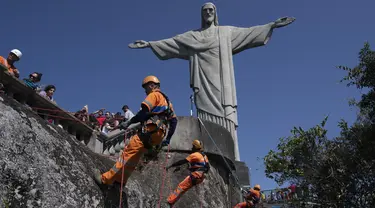 Para pembersih sampah menuruni Gunung Corcovado untuk membuang sampah yang dibuang di lereng Patung Kristus Penebus di Rio de Janeiro, Brasil pada Kamis, 22 Agustus 2024. (AP Photo/Bruna Prado)