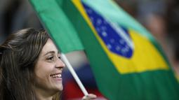 Suporter Brasil mengibaran bendera saat mendukung timnya melawan Ekuador pada laga kualifikasi Piala Dunia 2018 zona CONMEBOL di Porto Alegre, Brasil, (31/8/2017). Brasil menang 2-0.  (AP/Leo Correa)