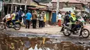 Sejumlah warga membaca koran di daerah kumuh Kawangare di Nairobi (10/8). Warga Kenya tengah gelisah menunggu hasil pemilihan presidennya, antara Uhuru Kenyatta dan pesaingnya, Raila Odinga. (AFP Photo/Tobin Jones)