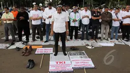 Massa yang tergabung dalam Aliansi TKI Menggugat melakukan unjuk rasa didepan Istana Merdeka, Jakarta,Selasa (7/4/2015). Massa juga menggelar salat bersama disela aksi unjuk rasa. (Liputan6.com/Helmi Afandi)