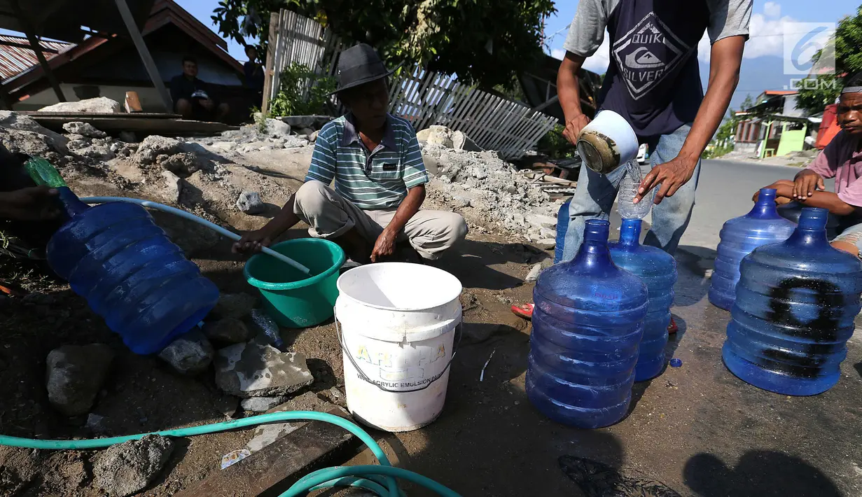 Warga antre memanfaatkan air bersih dari kebocoran pipa PDAM di Jalan Lagarutu, Palu Sulawesi Tengah, Rabu (3/10). Pasca gempa tsunami warga sekitar belum mendapatkan pasokan makanan dan air bersih. (Liputan6.com/Fery Pradolo)