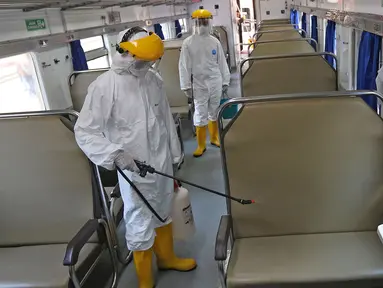Petugas melakukan penyemprotan disinfektan pada gerbong kereta api di Stasiun Pasar Senen, Jakarta, Minggu (15/3/2020). PT KAI Daop I Jakarta melakukan penyemprotan disinfektan dan pembersihan KA jarak jauh untuk antisipasi dan pencegahan penyebaran COVID-19. (Liputan6.com/Herman Zakharia)
