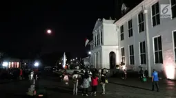 Warga menyaksikan gerhana bulan total di Kota Tua Jakarta, Rabu (31/1). Kegiatan tersebut dilakukan di halaman Museum Fatahillah. (Liputan6.com/Arya Manggala)
