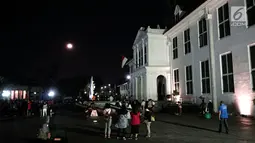 Warga menyaksikan gerhana bulan total di Kota Tua Jakarta, Rabu (31/1). Kegiatan tersebut dilakukan di halaman Museum Fatahillah. (Liputan6.com/Arya Manggala)