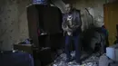 Seorang penduduk setempat mengumpulkan barang-barang dari rumahnya yang rusak berat setelah serangan Rusia di Pokrovsk, Ukraina timur, Rabu (25/5/2022). Dua roket menghantam kota Pokrovsk, di wilayah Donetsk pada Rabu pagi, menyebabkan sedikitnya empat cedera. (AP Photo/Francisco Seco)