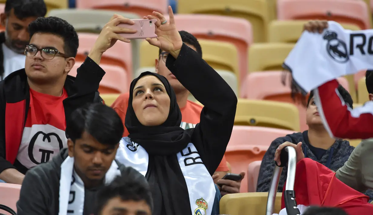 Suporter perempuan mengabadikan foto sebelum dimulainya pertandingan antara Valencia melawan Real Madrid pada semifinal Piala Super Spanyol King Abdullah Sport City di kota pelabuhan Arab Saudi, Jeddah (8/1/2020). (AFP/Fayez Nureldine)