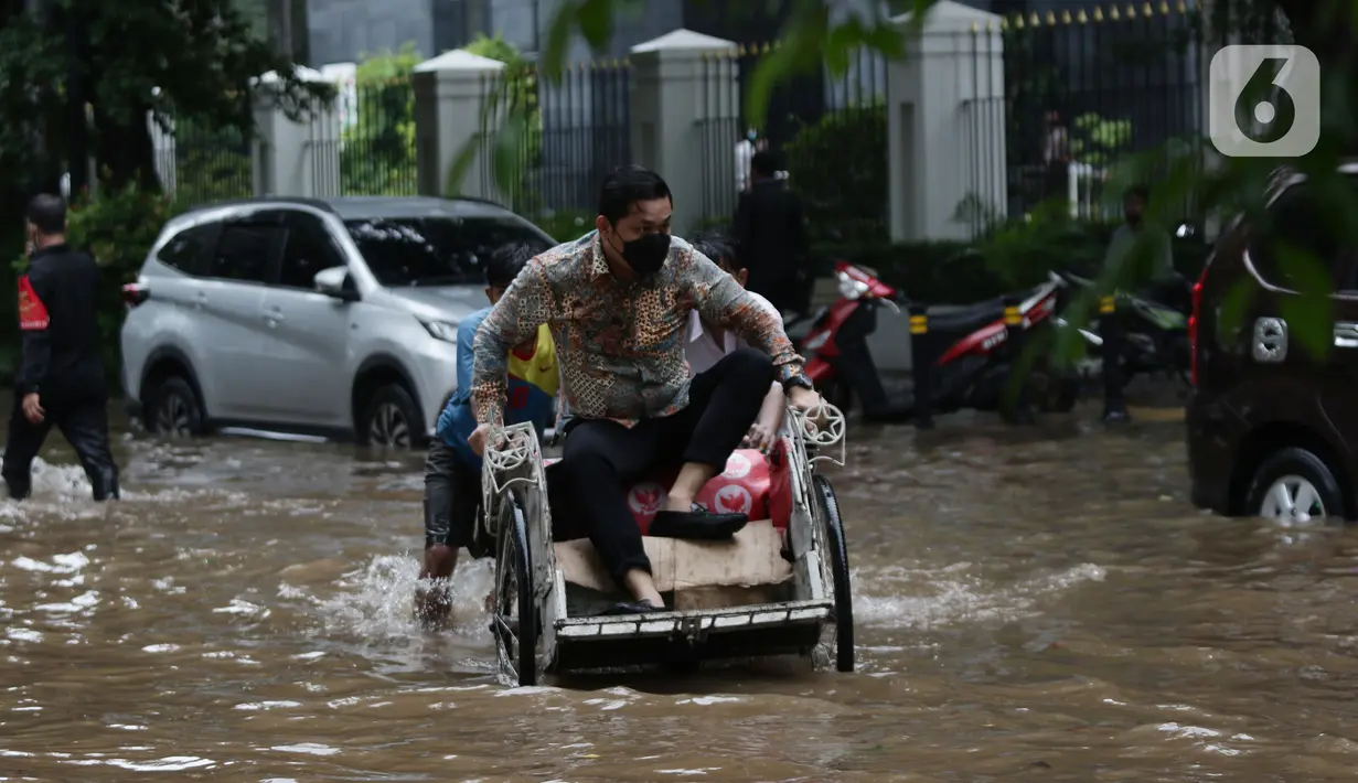 Warga menggunakan jasa becak untuk menembus sebagian Jalan Bungur Besar Raya yang tergenang air, Jakarta, Selasa (18/1/2022). Genangan air membuat arus lalu lintas di sekitar depan PN Jakarta Pusat menjadi terganggu dan tersendat. (Liputan6.com/Helmi Fithriansyah)