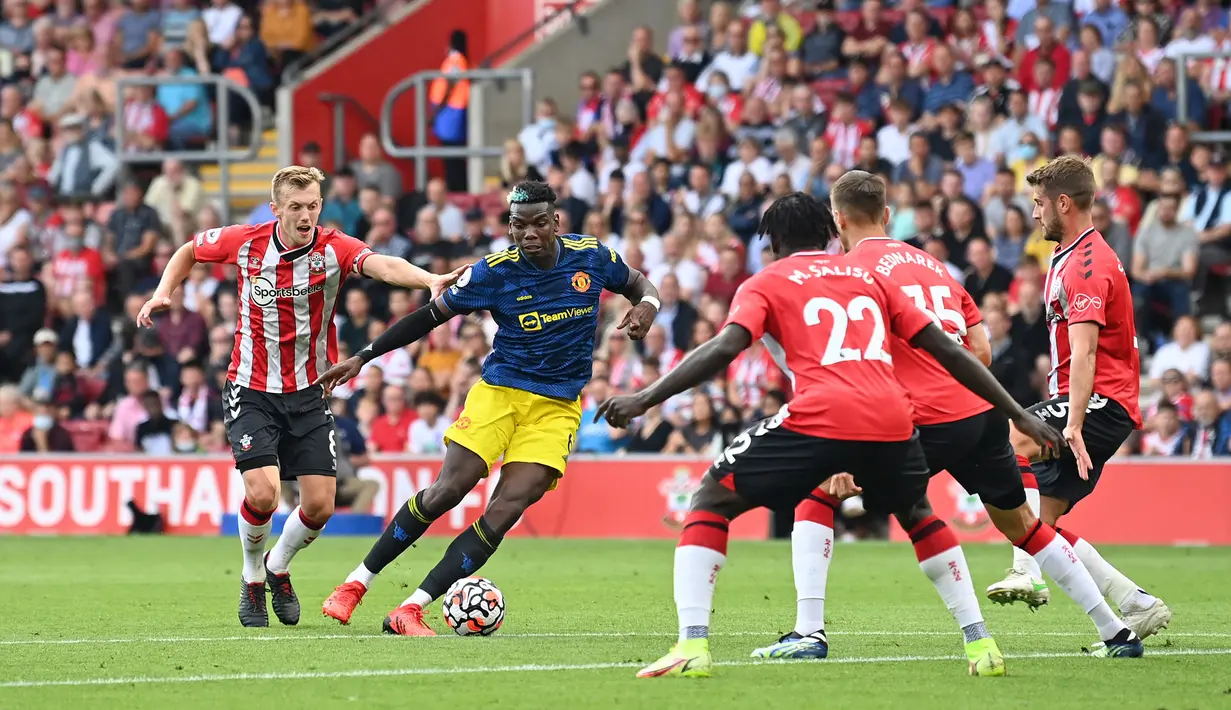 Pemain Manchester United Paul Pogba (kedua dari kiri) berlari ke arah gawang ketika pemain Southampton James Ward-Prowse (kiri) mengejar balik pada pertandingan Liga Inggris di Stadion St Mary, Southampton, Inggris, 22 Agustus 2021. Pertandingan berakhir imbang 1-1. (Glyn KIRK/AFP)