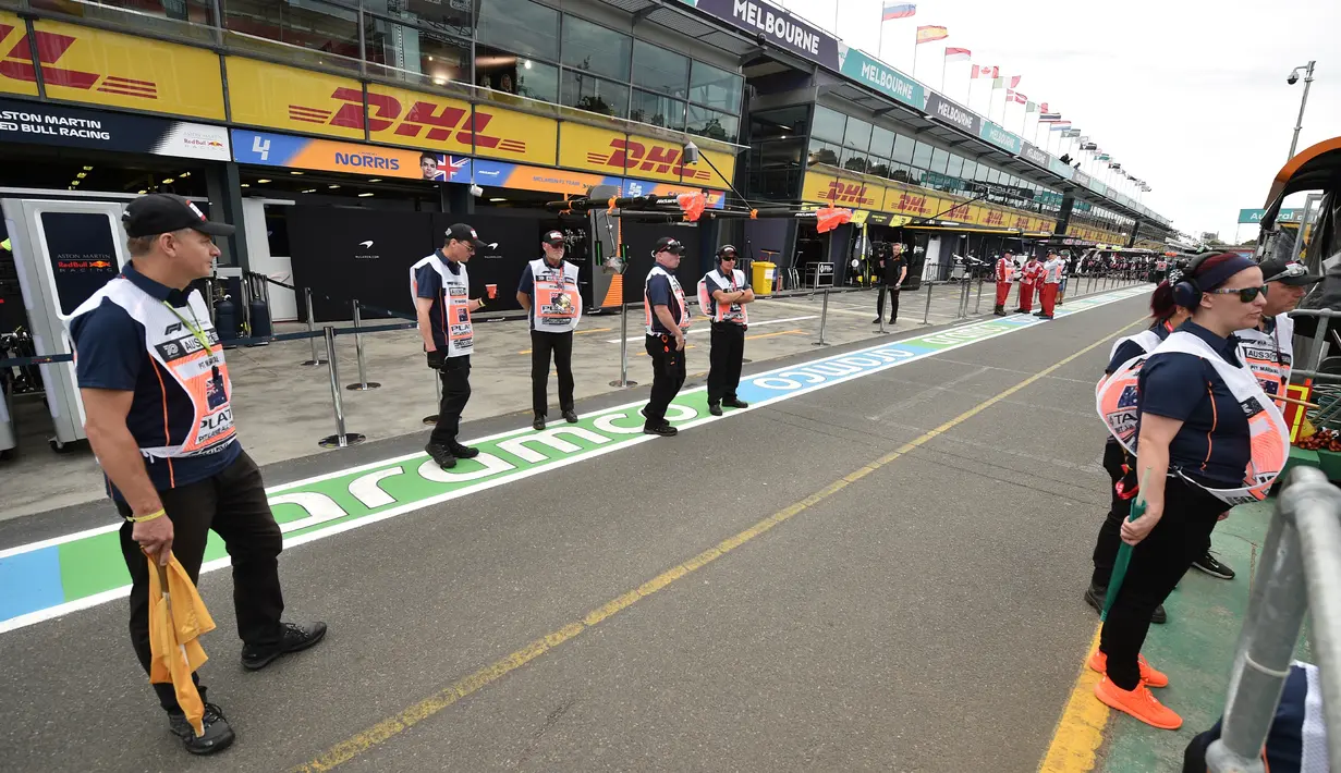 Tim berdiri di luar lapangan sebelum Formula 1 Australia Grand Prix dibatalkan di Melbourne, Jumat (13/3/2020). Pembatalan F1 Australia menjadi lanjutan dari keputusan Mclaren yang sudah menyatakan mundur dari balapan. (Peter PARKS/AFP)
