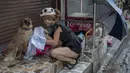 Seorang wanita mengeringkan anjing liar yang basah setelah hujan di Bangkok, Thailand, Rabu (17/6/2020). Keseharian warga Bangkok berangsur normal setelah pemerintah terus melonggarkan pembatasan terkait pandemi virus corona COVID-19. (AP Photo/Gemunu Amarasinghe)