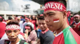 Suporter Garuda Muda mengecat pipinya dengan gambar bendera Merah Putih untuk mendukung Timnas Indonesia U-22 pada laga melawan Timor Leste, Minggu (20/8). Indonesia melakoni laga ketiga dalam lanjutan grup B SEA Games 2017. (Liputan6.com/Faizal Fanani)