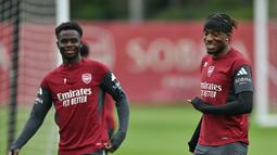 Senyum sumringah pemain Arsenal, Bukayo Saka (kiri) dan Noni Madueke (kanan) pada sesi latihan jelang leg kedua semifinal Liga Champions melawan Atletico Madrid di Emirates Stadium, London, Rabu (6/5/2026) dini hari WIB. (AP Photo/Steven Paston)