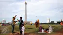 Sejumlah pengunjung bermain layang-layang di kawasan Monas, Jakarta, Sabtu (26/12/2015). Libur Natal dimanfaatkan sejumlah warga untuk berwisata ke tempat yang menjadi ikon Jakarta tersebut. (Liputan6.com/Yoppy Renato)