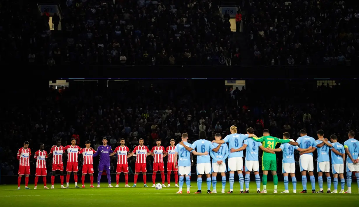 Pemain Manchester City (kanan) dan Red Star Belgrade berdiri saat mengheningkan cipta untuk mengenang para korban banjir Libya dan gempa Maroko sebelum pertandingan sepak bola Grup G Liga Champions antara Manchester City dan di Manchester, Inggris, Selasa (19/9/2023). Banjir Libya menewaskan lebih dari 11.000 orang dan 10.100 lainnya hilang, sementara gempa Maroko menewaskan setidaknya 2.900 orang. (AP Photo/Dave Thompson)