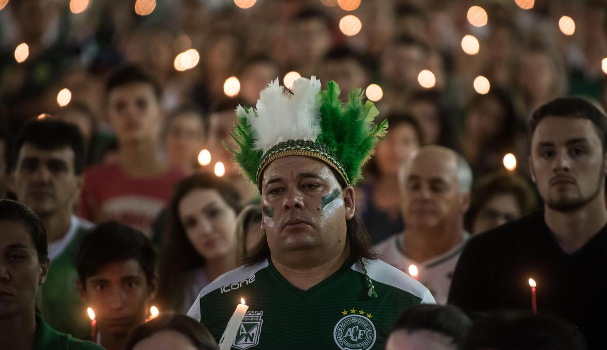 Seorang fans Chapecoense dengan penutup kepala berbulu memperingati satu tahun kecelakaan pesawat Lamia 2933 di Arena Conda stadium, Chapeco, Santa Catarina, Brasil, (28/11/2017). Sekitar 19 pemain Chapecoense meninggal. (AFP/Nelson Meida)