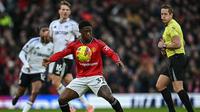 Gelandang Manchester United, Kobbie Mainoo (depan), mengontrol bola pada laga melawan Fulham pada lanjutan Liga Inggris di Old Trafford, Minggu (1/2/2026). (Paul Ellis/AFP)