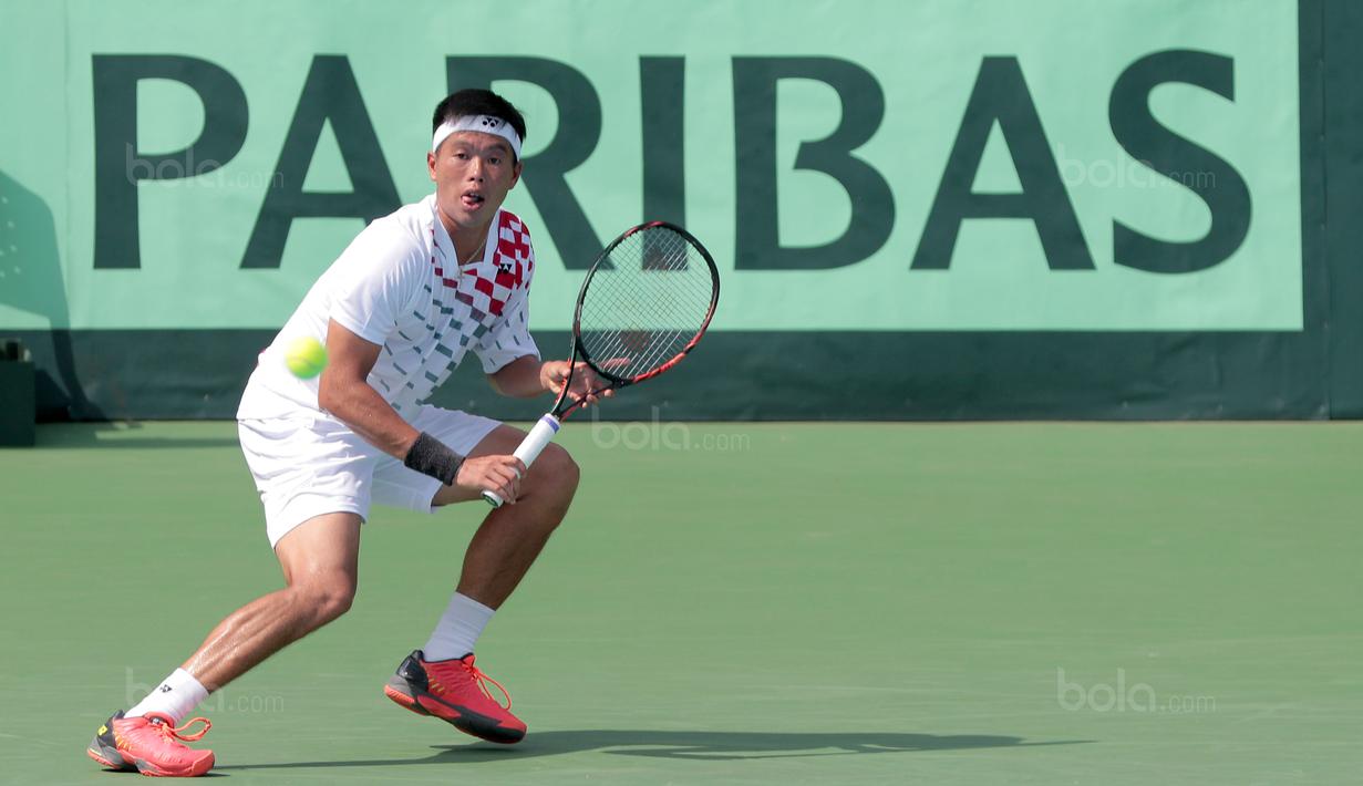 Petenis Indonesia, David Agung Susanto mencoba mengembalikn bola ke petenis Filipina pada Piala Davis 2018 grup dua Asia/Oceania di Senayan, Jakarta, Sabtu (3/2/2018). David menang 6-2, 7-5. (Bola.com/Nick Hanoatubun)